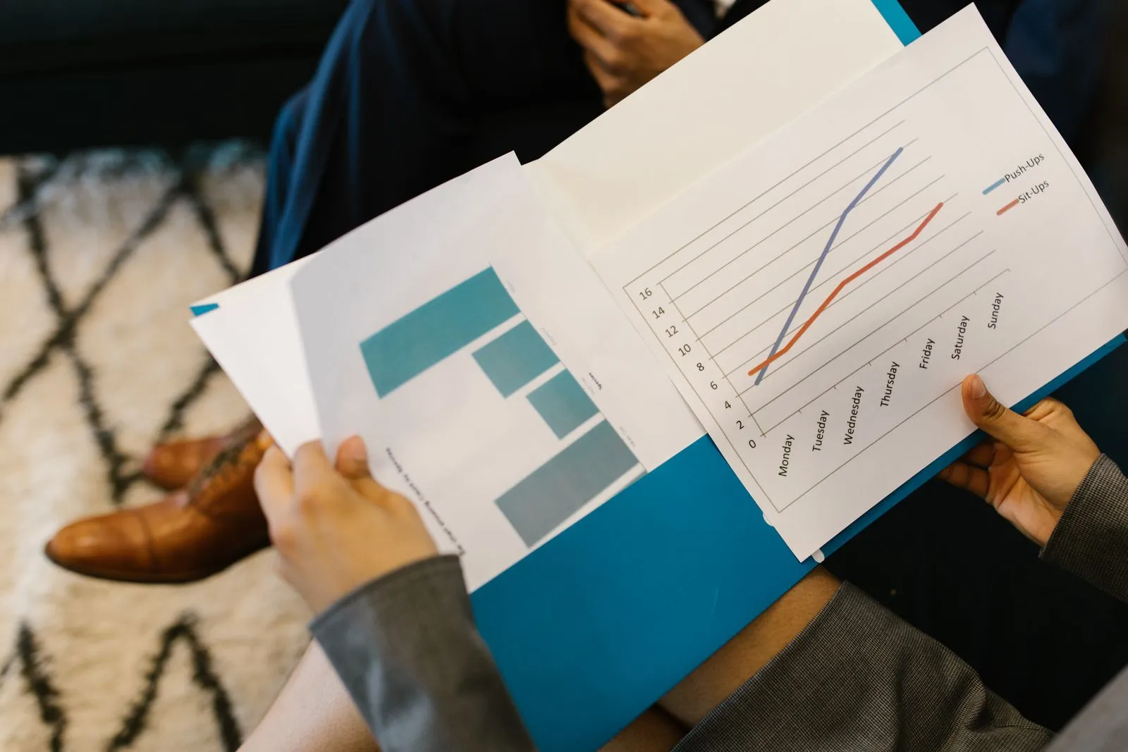 Pessoas analisando relatórios com gráficos impressos